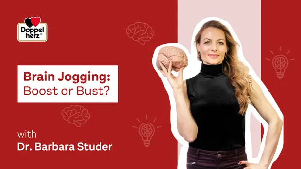 Image d'une femme tenant un cerveau en plastique, posant à côté du texte "Brain Jogging: Boost or Bust?" avec le nom "Dr. Barbara Studer". En arrière-plan, des illustrations de cerveaux et d'ampoules. Couleurs dominantes : rouge et blanc.